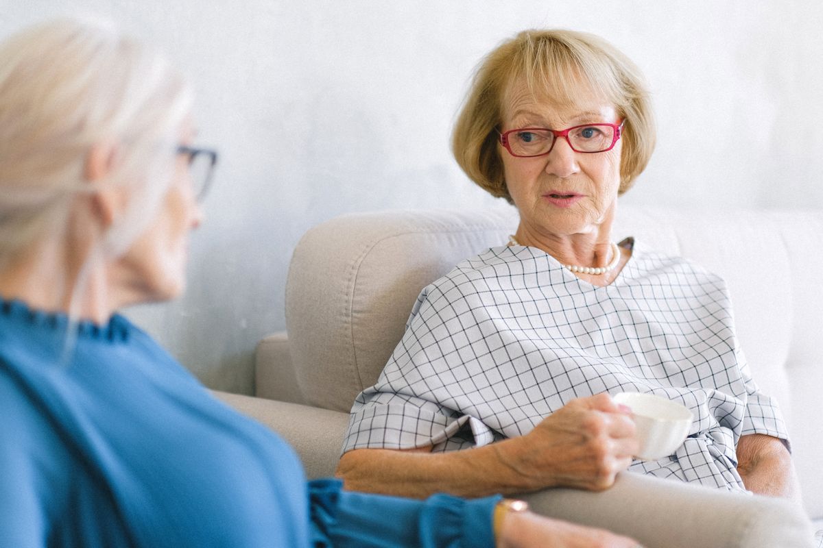Two older women enjoying tea and conversation together
